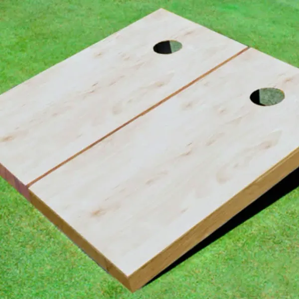 A wooden cornhole board on grass