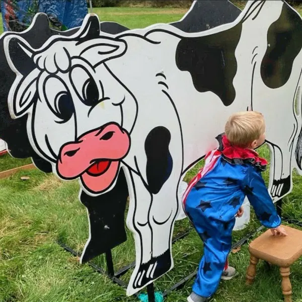 A child milking the dairy cow simulator at an outdoor event